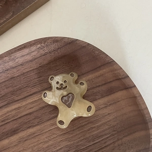 Gros plan sur accessoire en résine d'ours brun mignon avec détail de cœur foncé
