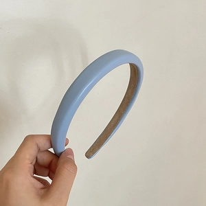 Detail of light blue faux leather headband featuring a brown non-slip lining