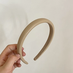 Detail view of thickened beige faux leather headband with non-slip brown velvet inner lining