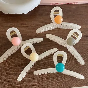 Acrylic shark hair claw clips set with colorful candy beads on a wooden background