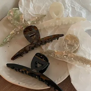 Lot de cinq grandes pinces à cheveux en acétate aux motifs floraux et marbrés sur plateau