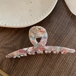 Détail d'une grande pince à cheveux en acétate avec un motif de marbre coloré élégant