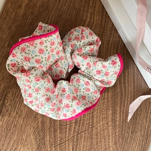 Detail of floral scrunchie with pink flowers and bright magenta border on wood