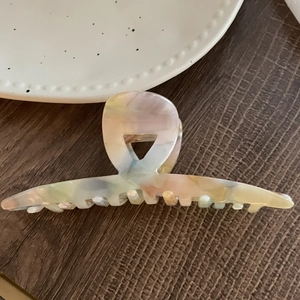 Détail d'une grande pince à cheveux en acétate avec texture marbrée rose et jaune