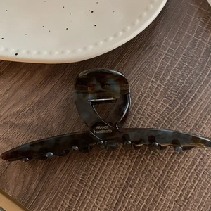 Gros plan détaillé sur pince à cheveux en écaille foncée avec logo France Handmade doré
