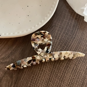 Détail d'une pince à cheveux en acétate faite main avec motif marbré coloré sur bois