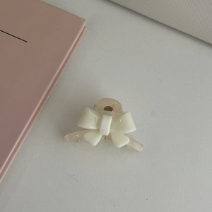 Pince à cheveux élégante avec nœud crème en soie et base en acrylique couleur champagne