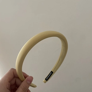 Elegant bright yellow padded headband made of smooth satin fabric with a high crown design