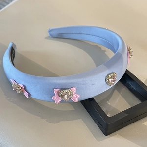 Blue satin padded headband featuring pink ribbon bows and heart crystal embellishments
