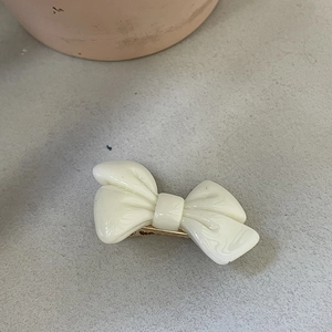 Détail d'une pince à cheveux nœud crème avec texture marbrée et fermoir doré