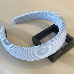 Macro detail of padded light blue headband with textured twill fabric and soft shadows