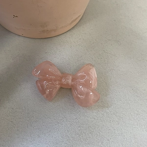 Vue détaillée de la texture marbre rose sur l'élégante pince à cheveux en nœud