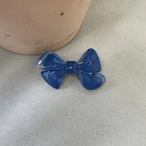 Détail d'une pince à cheveux nœud bleu foncé translucide avec finition résine brillante