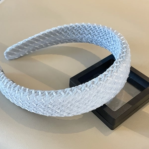 Detail of light blue woven headband with a textured fabric finish on a display stand