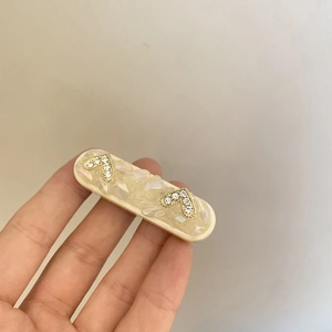 Barrette élégante avec pierres irisées et accents de cristal dorés en forme de V