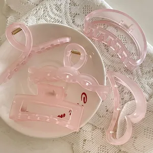 Détails de diverses grandes pinces à cheveux rose mat sur dentelle et céramique