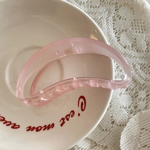 Grande pince à cheveux rose mat pour femme sur une assiette avec dentelle blanche élégante