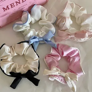 Detailed close-up of premium satin hair scrunchies with elegant ribbon bows in four colors