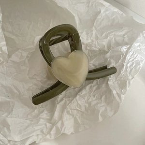 Sweet heart-shaped hair claw clip in dark green with cream acrylic heart decoration