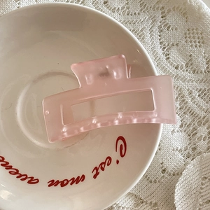 Pince à cheveux carrée rose mat sur plateau en céramique avec dentelle élégante