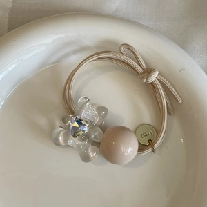 Rosa Bär Haargummi mit Kristallbär, Herzstein und Goldanhänger auf Keramikschale