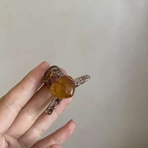 Macro detail of amber resin hair claw clip with heart shaped accent and metal spring