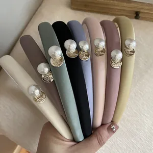 Detail of satin sponge headbands in eight soft colors with pearl and gold tag accents