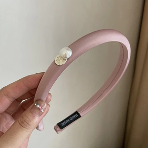 Pink satin padded headband featuring an elegant white pearl and engraved gold metal charm