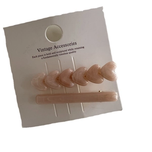 Two-piece pink acrylic heart hair clip set with marble texture on white vintage card