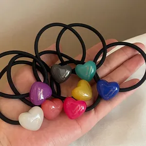 Colorful acrylic heart-shaped hair ties set with golden engraving and elastic bands