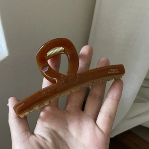 Macro detail of amber large hair claw clip featuring golden France Handmade text logo