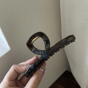 Close-up of tortoise shell leopard print hair claw clip with gold France Handmade logo