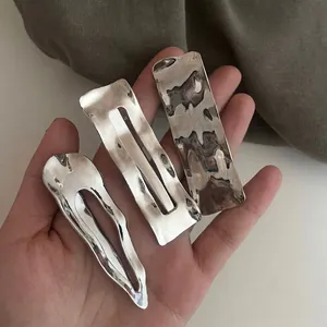 Three-piece silver wavy metal hair clips set with minimalist glossy metallic texture
