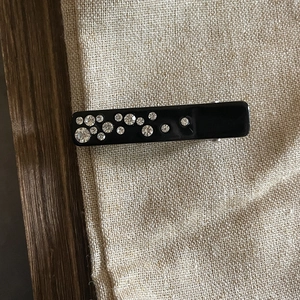 Fermaglio rettangolare nero stile francese con strass scintillanti su sfondo lino