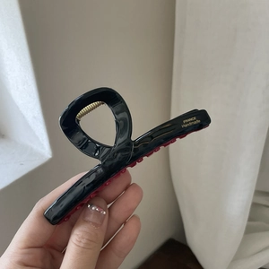 French style black large hair claw clip with red teeth and gold metal spring details