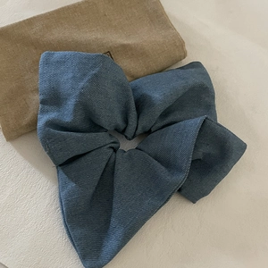 Classic blue denim scrunchie with twill texture and natural pleats for hair styling