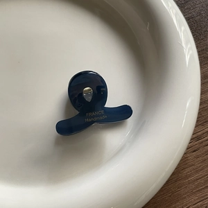 Close-up of small dark blue acetate hair claw clip with gold France Handmade lettering