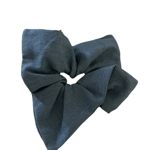 Dark blue denim scrunchie with twill texture and pleated design on white background