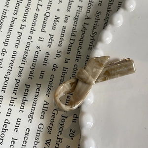 Detail of marble pattern acetate bow hair clip with metal spring on a French book