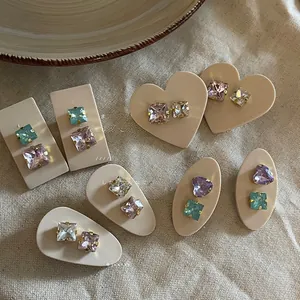 Detailed view of colorful geometric heart rhinestones on acrylic clips and gold studs