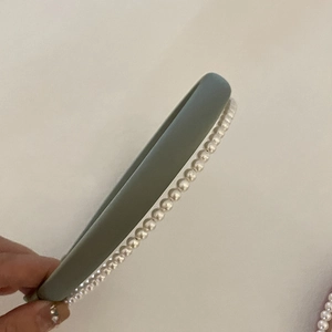 Détail d'un serre-tête élégant à double couche avec perles blanches et bande grise