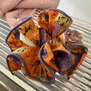 Gros plan d'un chouchou floral aux motifs de tournesol sur une plaque en verre
