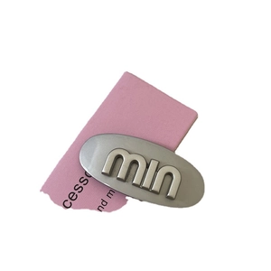 Brushed silver metal oval hair clip with engraved lettering and luxury style