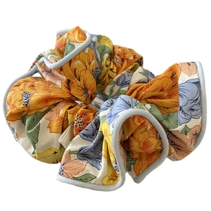 Chouchou à fleurs avec motifs orange et roses sur un fond blanc propre et net