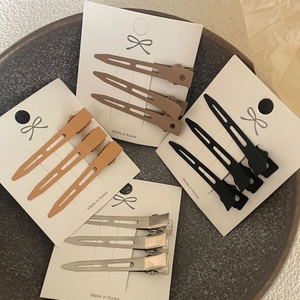 Set of hair root clips in matte coffee, orange, black, and silver for volume styling