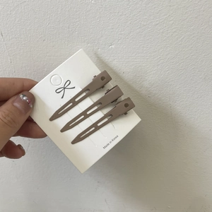 Close-up of matte brown hair root volume clips on display card for hair styling