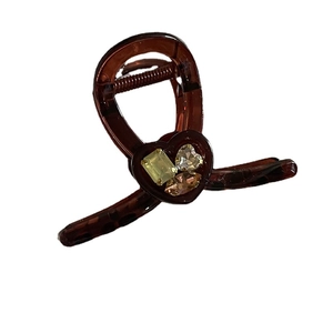 Elegante pinza per capelli a cuore ambra con strass sfaccettati su sfondo bianco puro