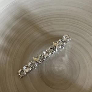 Detail of silver alloy star hair clip featuring sparkling rhinestones and chain design