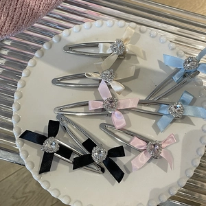Set cremefarbene Satin Schleifen Haarklammern mit Herz-Strass auf elegantem Porzellanteller