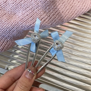 Zwei blaue Schleifen-Haarspangen mit herzförmigen Strasskristallen und silbernen Clips